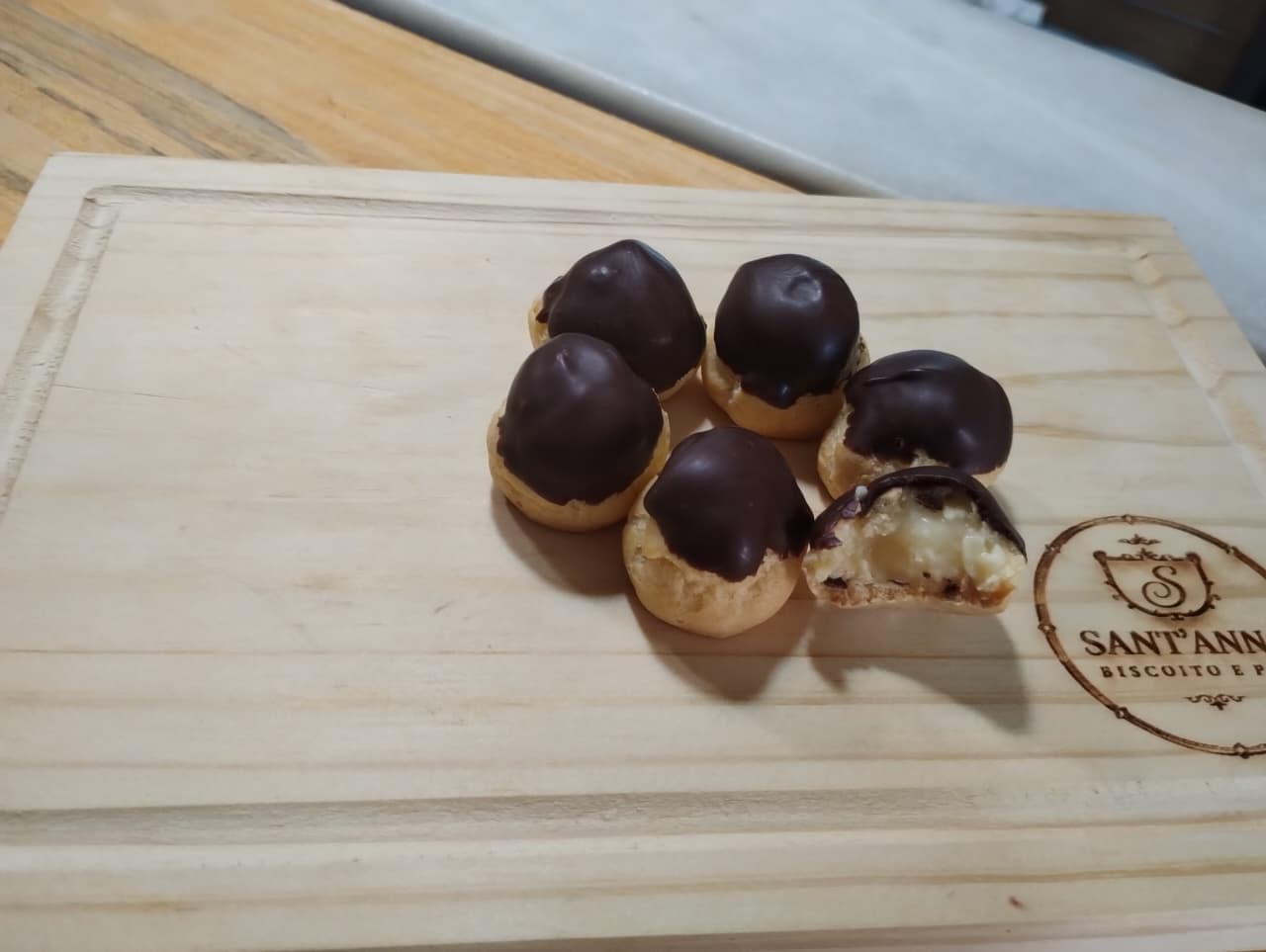Carolina de creme: Assadas, recheadas com creme depois de prontas e finalizadas com cobertura de chocolate. Vendidas por peso.